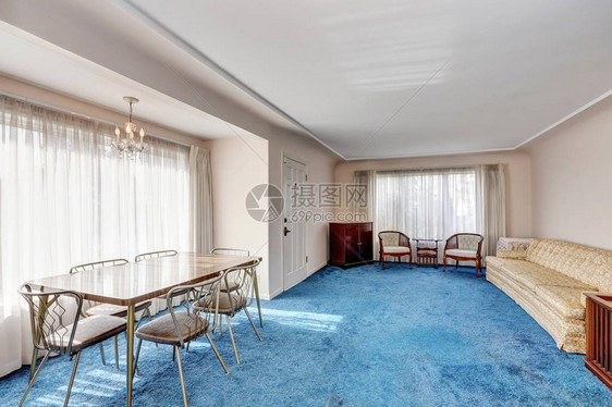 工匠风格的内饰入口房间与用餐区相连复古家具六人餐桌和蓝色柔软的地毯板图片