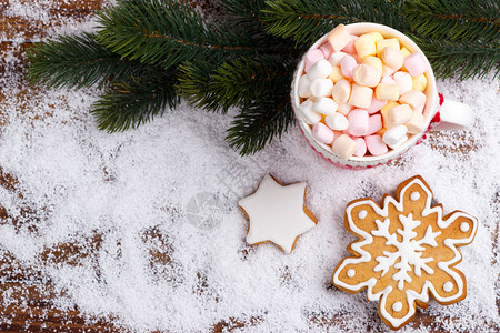 热巧克力和融化的棉花糖加红杯和雪上姜面包饼干顶图片