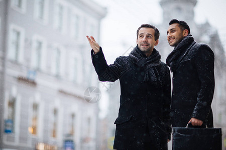 下雪天商人们站在一起在户外交流图片