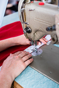 在裁缝车间使用缝纫机的女人手图片