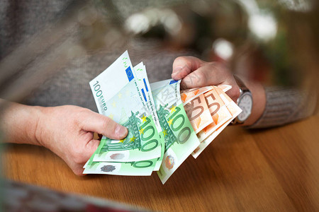 男手认为欧元纸币面额为100和50欧元的欧元纸币富有的商图片