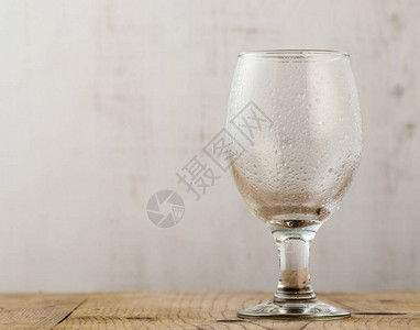 木桌上有水滴的空啤酒杯图片