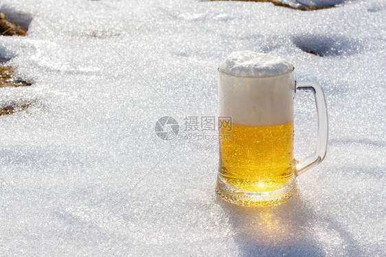 在春天融雪的背景下喝啤酒图片