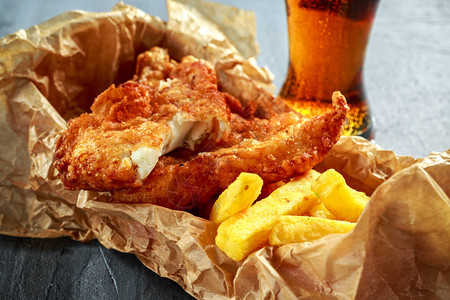 英国传统鱼和冷啤酒碎纸中的薯图片