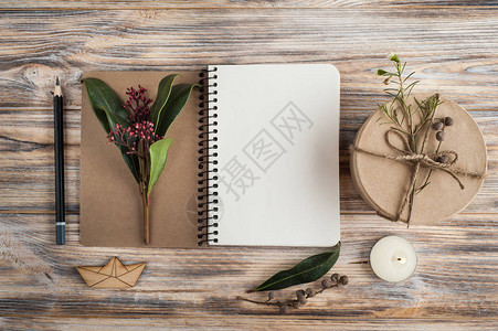 礼品开放式笔记本和木制背景的花装饰图片