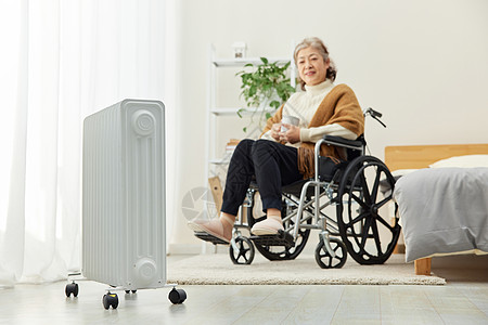 坐轮椅的居家老人使用暖气片取暖图片