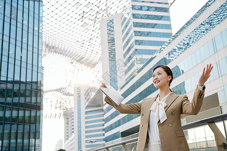 站的高站在室外使用笔记本的商务女性背景