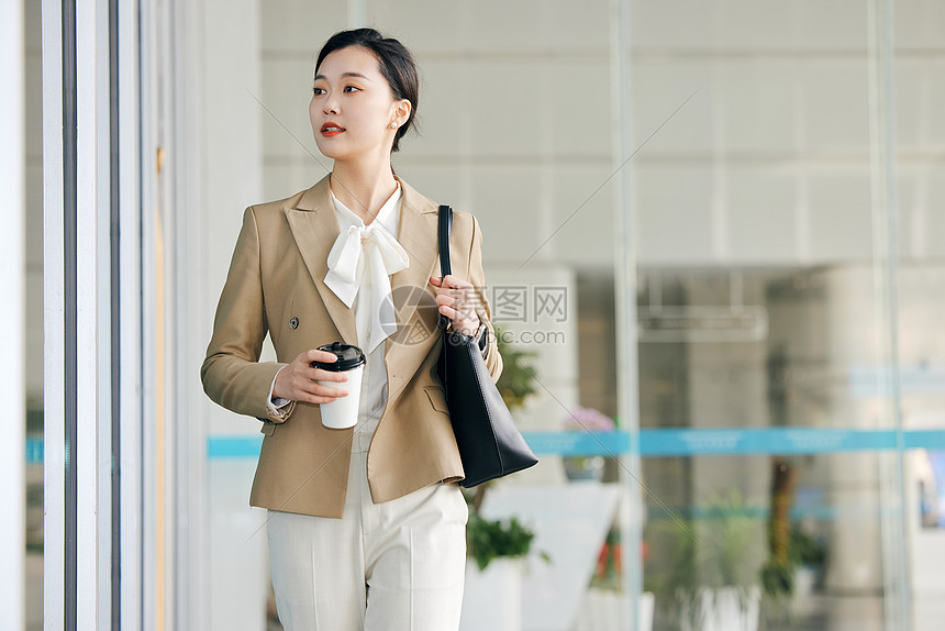 手拿咖啡杯步行的上班族高清图片下载-正版图片507606742-摄图网