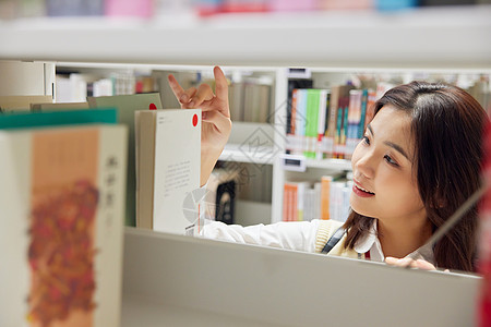 在图书馆里借书的女学生背景图片