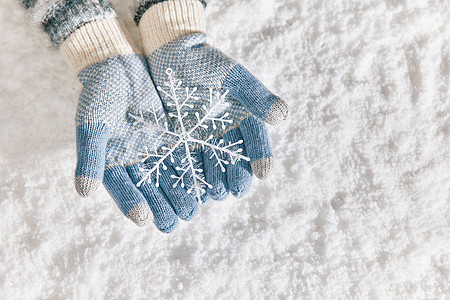 雪地里戴手套手捧雪花片特写高清图片