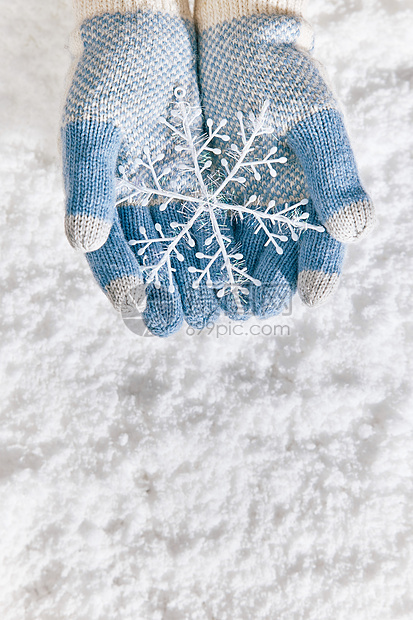 雪地里手捧雪花片特写图片