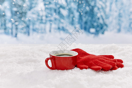 雪地上的红色马克杯和手套图片