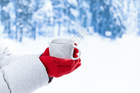 雪地里手捧马克杯特写图片