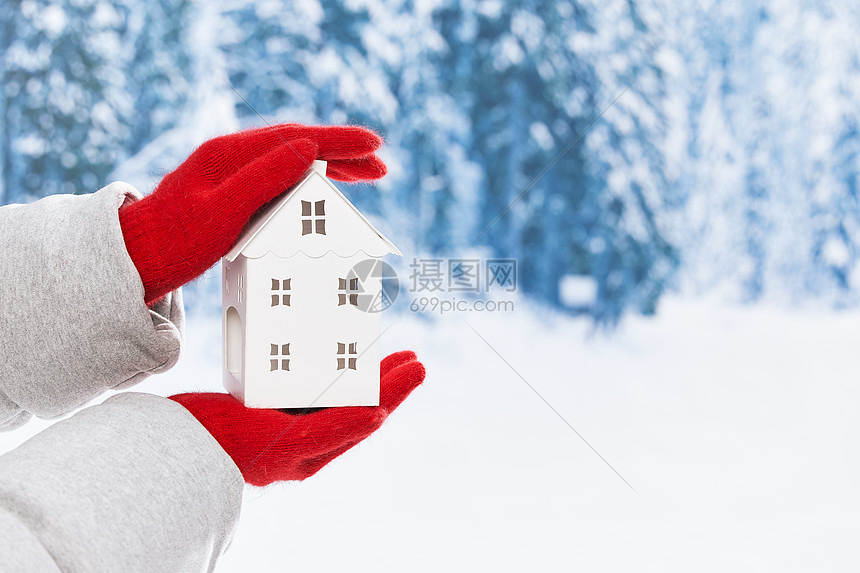 雪地里手拿白色小房子特写图片