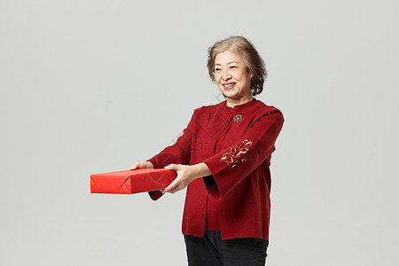 新年形象老奶奶递春节礼盒背景图片