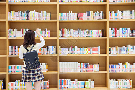 在图书馆里找书的女学生背影高清图片