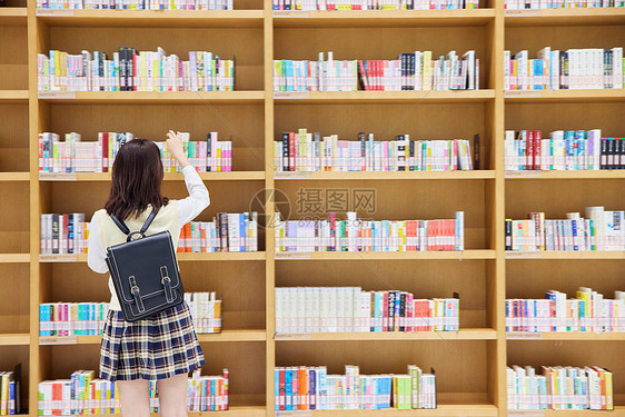 在图书馆里找书的女学生背影图片