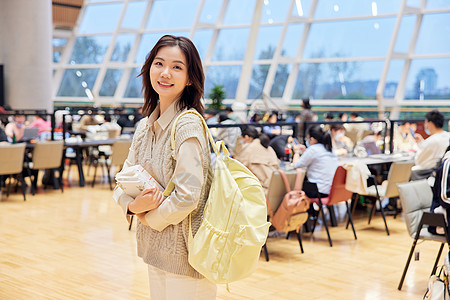 图书馆里抱着书本的年轻女生高清图片