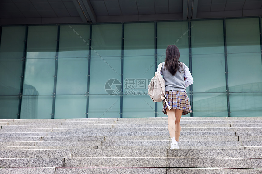 女学生行走在校园背影图片