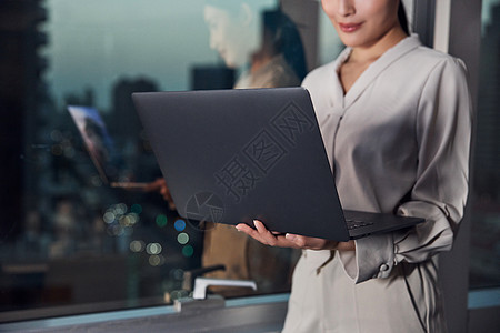 电脑酒店素材商务女性站在窗边使用电脑背景