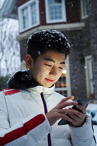 男孩在院子里玩手机图片