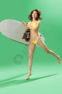 兴奋的青年女人抱着冲浪板图片