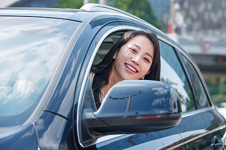 驾驶汽车的青年女人将头伸出窗外高清图片