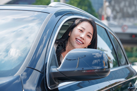 驾驶汽车的青年女人将头伸出窗外图片