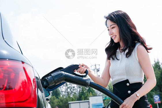 青年女人给汽车充电图片