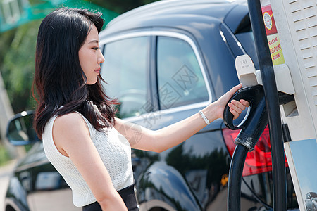 美女,车从充电桩取充电的漂亮青年女人背景