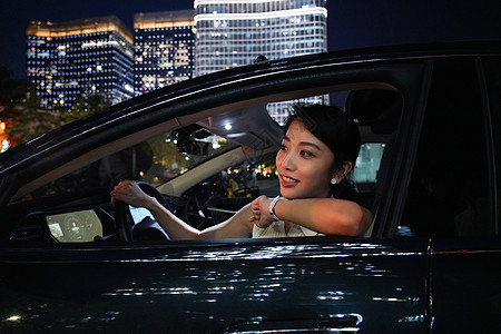 夜晚快乐的青年女人驾驶汽车图片