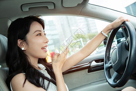 青年女人边开车边语音聊天高清图片