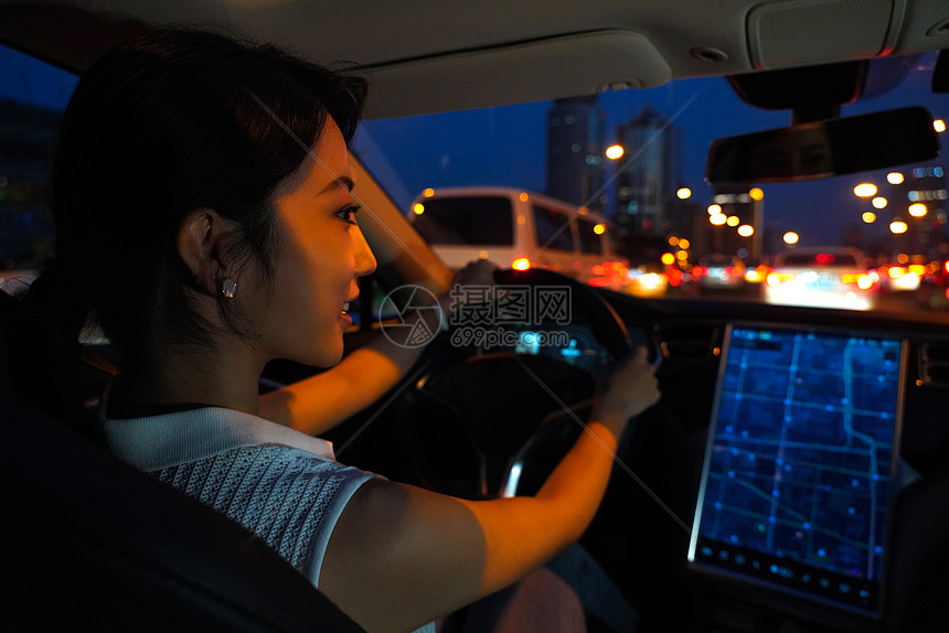 夜晚开车的青年女人看屏幕导航图片