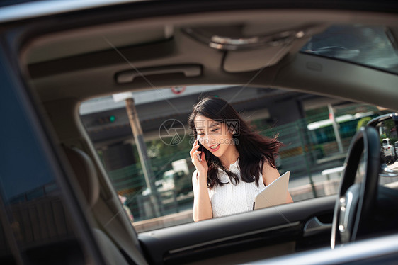 打电话的青年女人走向汽车图片