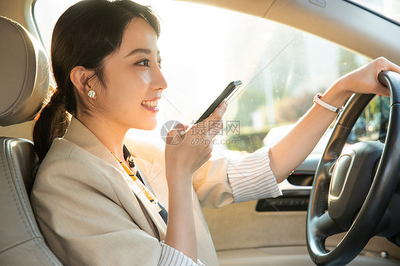 漂亮的青年女人边开车边语音聊天图片