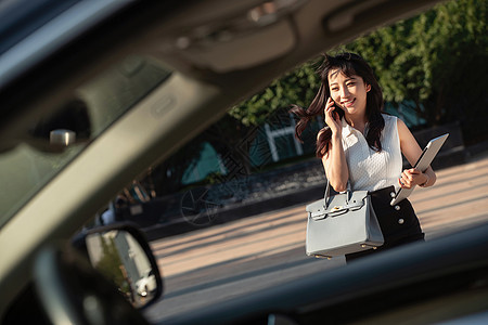 打电话的青年女人走向汽车图片