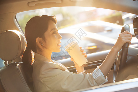 开车喝咖啡的青年女人图片