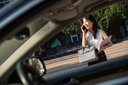 打电话的青年女人走向汽车图片