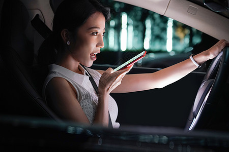 驾驶汽车的青年女人使用手机语音聊天图片