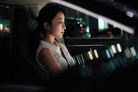 夜晚坐在汽车里的青年女人图片素材