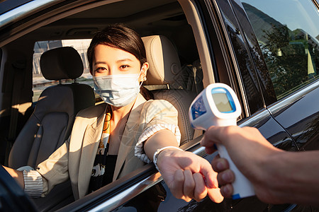 给驾车的青年女人测量体温图片