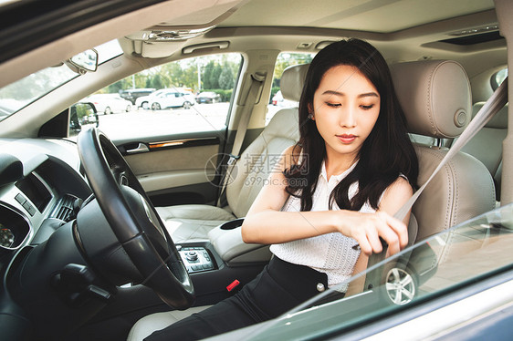 驾车前系安全带的青年女人图片