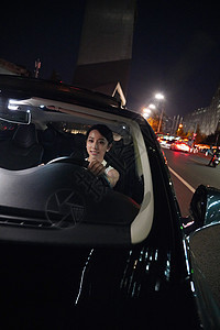 夜晚快乐的青年女人驾驶汽车图片