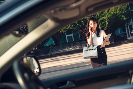 打电话的青年女人走向汽车图片