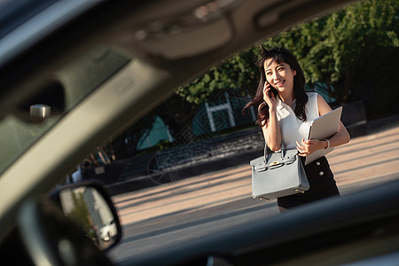 打电话的青年女人走向汽车图片