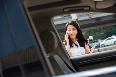 打电话的青年女人走向汽车图片