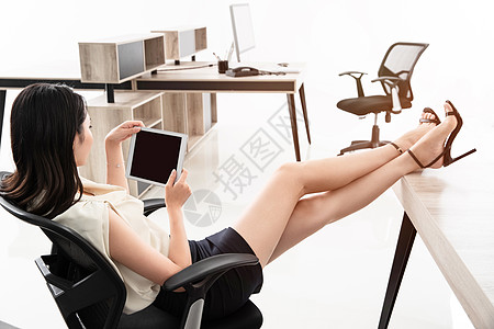 商务女士坐在椅子上用平板电脑图片