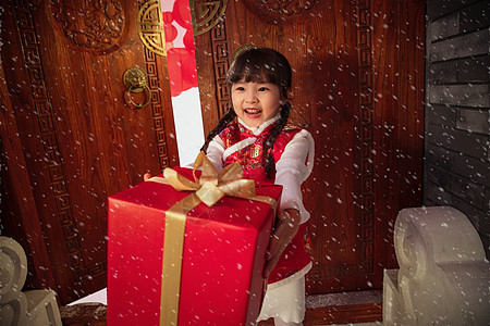 拜年的可爱小女孩拿着礼品盒图片