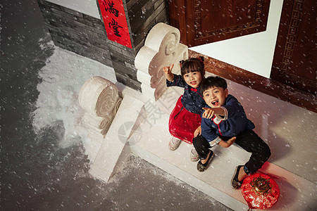 坐在门口台阶上看雪花的男孩女孩图片