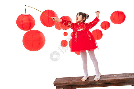 红灯笼旁提着灯笼玩耍的小女孩图片